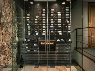 Contemporary wine cellar wall enclosed in glass doors feature floor and wall metal wine racking.