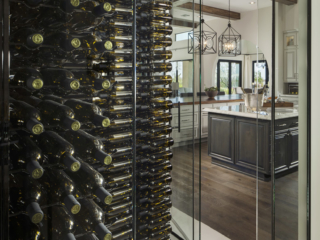 Dual entry wine cellar with glass doors and walls to match rustic contemporary decor.