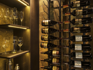 Wine cellar room with metal wine racks and dim lighting to match contemporary decor.