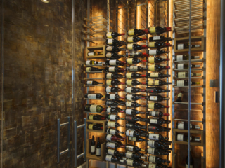 Wine cellar room with mixed metal and wood racking and accent back and ceiling lighting.