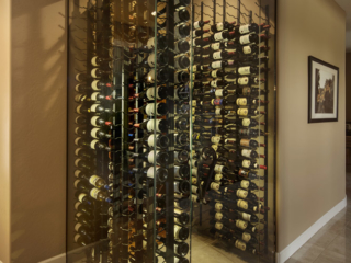 Contemporary style corner wall wine storage room with glass facing walls and metal wine racks.