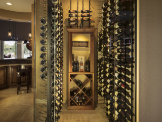 Contemporary style wine closet with glass walls and door with metal wall mounted wine racks.