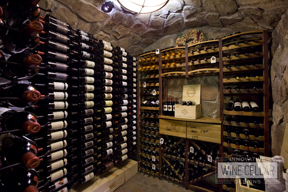 Rustic stone wine cellar & reclaimed wine barrel racking, created by Innovative Wine Cellar Designs.