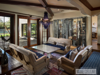 This glass wine wall cellar transforms the look of this cozy living room area, allowing light to pass through from the kitchen.