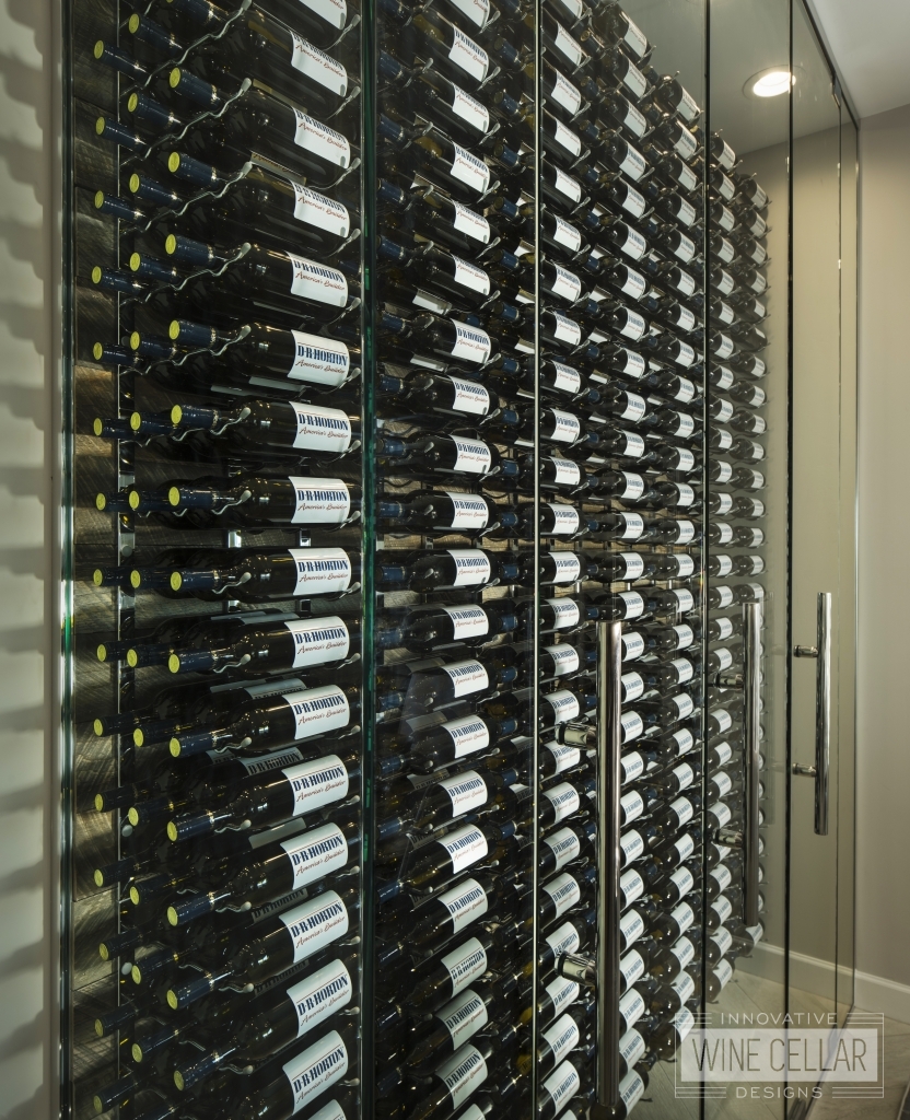 wine bottles in glass wine cellar wall